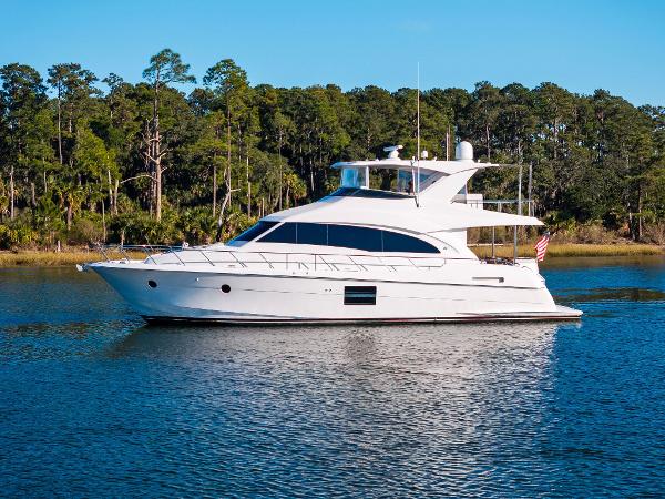Hatteras M60 2016 Hatteras M60 yacht cruising on a serene lake with forested background.