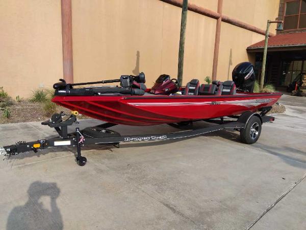 Ranger RT178 2025 Ranger RT178 boat in red, parked on a trailer outside a building.