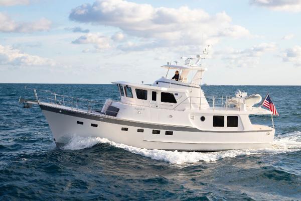 Krogen 52 2027 Krogen 52 yacht cruising on open sea under a partly cloudy sky.
