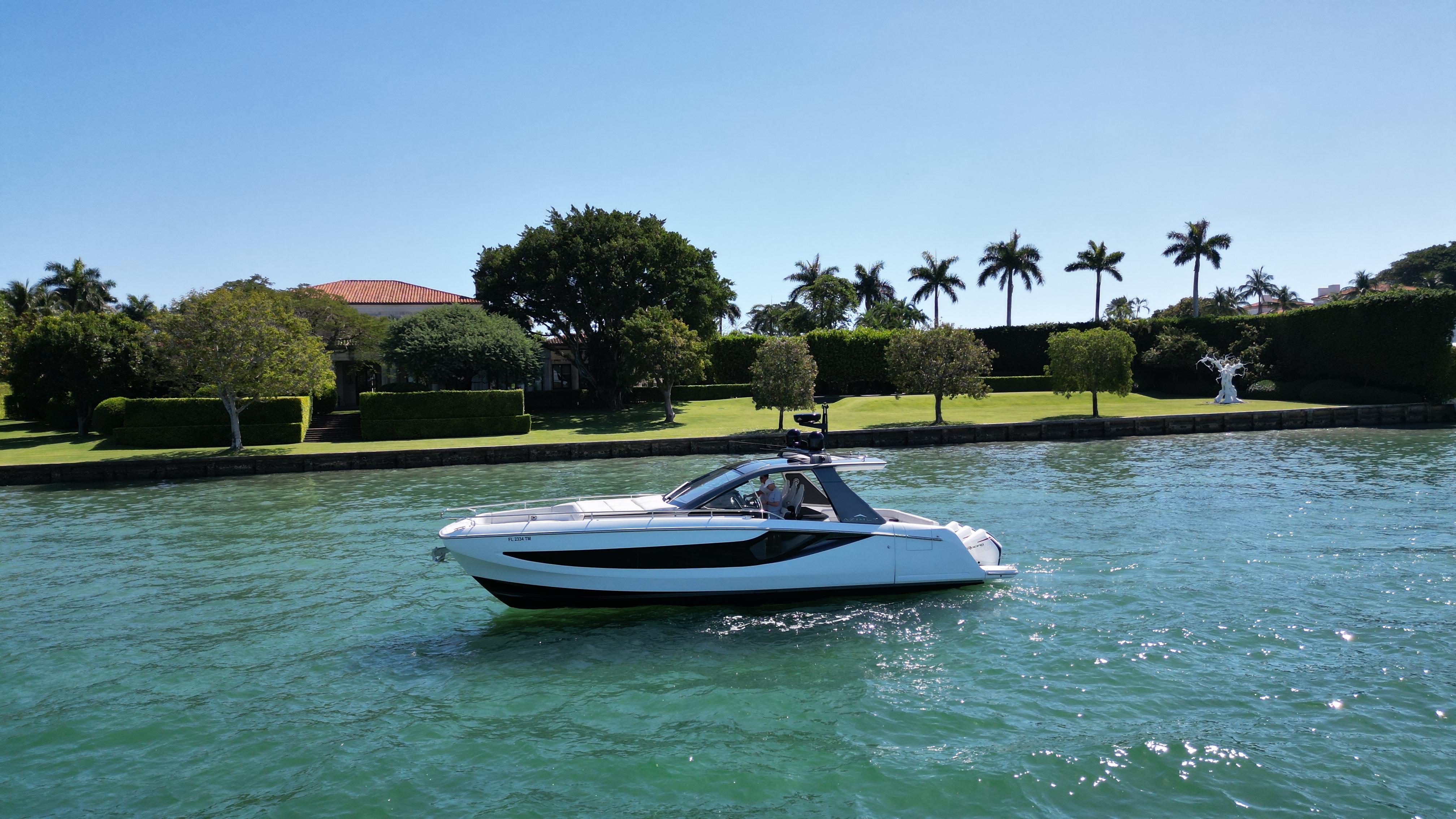 Azimut 42 VERVE 2023 Azimut 42 VERVE yacht cruising on a sunny day near a lush waterfront.