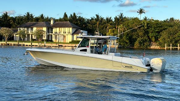 Boston Whaler 370 Outrage 2017 Boston Whaler 370 Outrage boat cruising near waterfront homes.