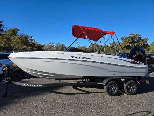 Tahoe T21 2025 Tahoe T21 boat with red canopy on trailer, parked outdoors.