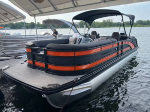 Bennington 25 RFB 2026 Bennington 25 RFB pontoon boat docked on a calm lake under a canopy.