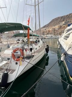 Beneteau Oceanis 44 CC 1997 Beneteau Oceanis 44 CC sailboat docked in a marina with scenic mountain backdrop.