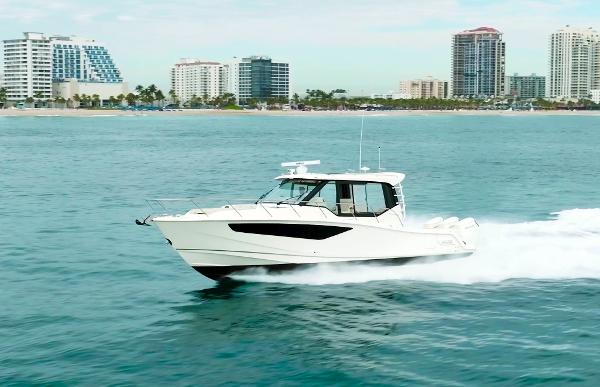 Boston Whaler 405 Conquest 2024 Boston Whaler 405 Conquest cruising near a coastal city skyline.