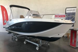 Quicksilver Activ 555 Open 2022 Quicksilver Activ 555 Open boat displayed indoors with promotional banners.
