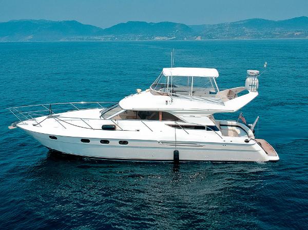 Viking 46 Flybridge Sport Cruiser 2000 Viking 46 Flybridge Sport Cruiser on open sea with mountainous backdrop.