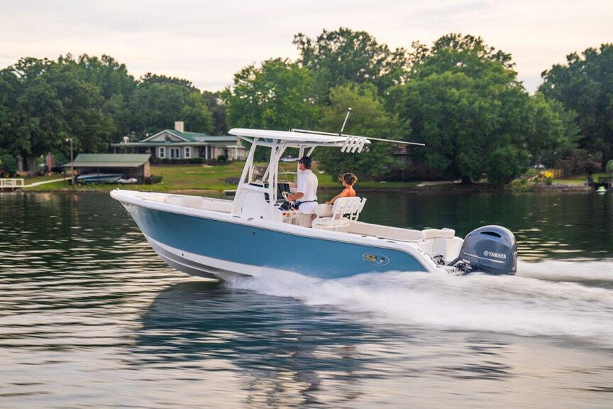 Sea Hunt Ultra 234 2026 Sea Hunt Ultra 234 boat cruising on a serene lake with lush greenery.
