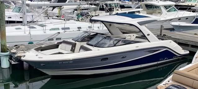 Sea Ray 310 SLX 2016 Sea Ray 310 SLX boat docked in a marina, surrounded by other vessels.