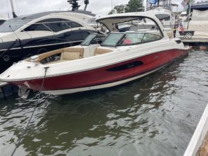 Sea Ray 350 SLX 2015 Sea Ray 350 SLX boat docked in marina, featuring sleek red and white design.