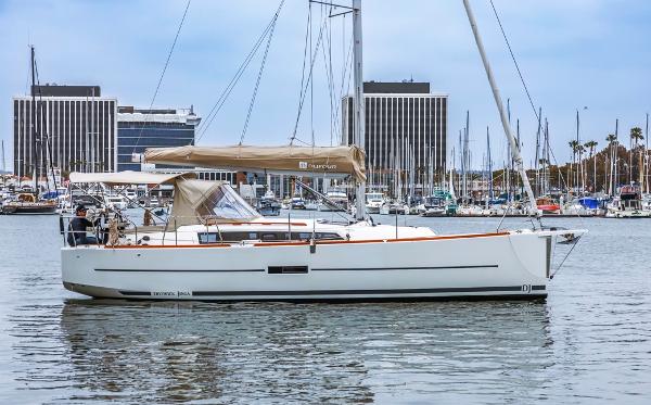 Dufour 360 2020 Dufour 360 sailboat docked in marina with cityscape background.