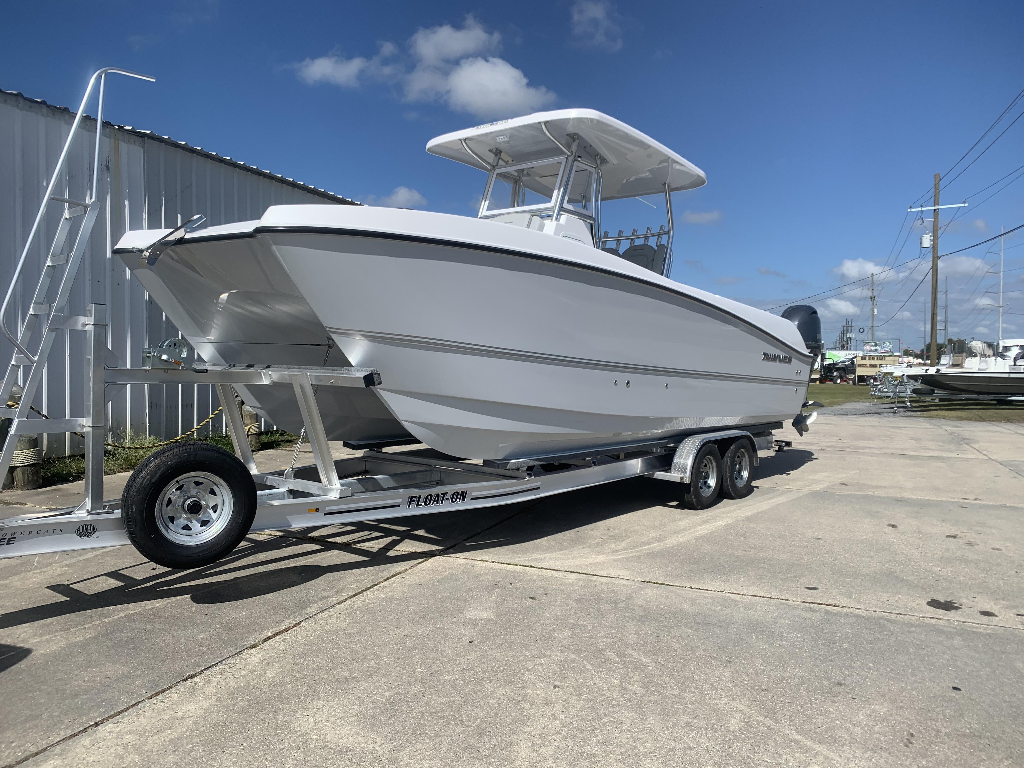 Twin Vee 260 GFX 2023 Twin Vee 260 GFX boat on a trailer, parked outdoors.