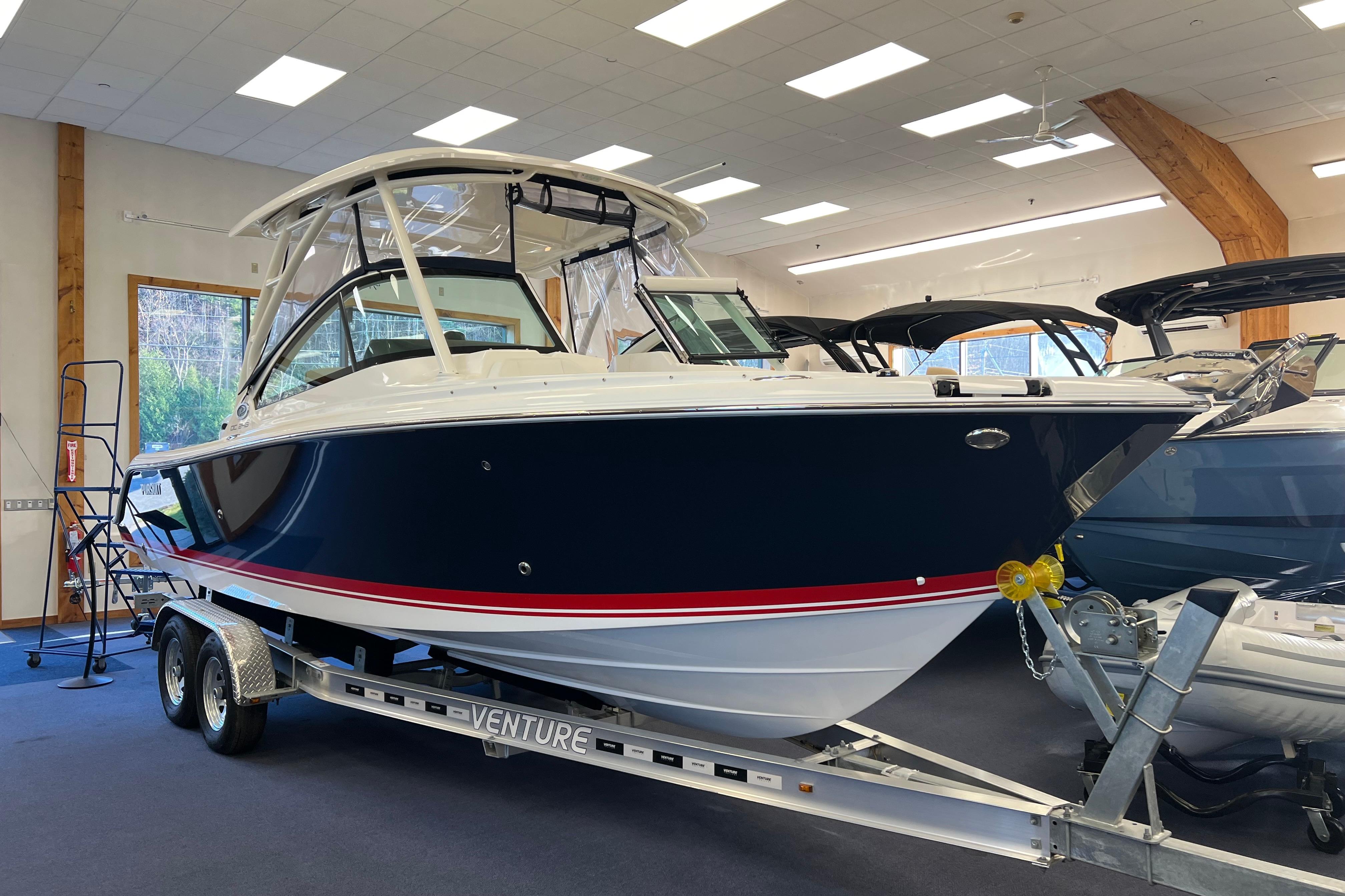 Pursuit DC 246 Dual Console 2025 Pursuit DC 246 Dual Console boat on trailer in showroom.