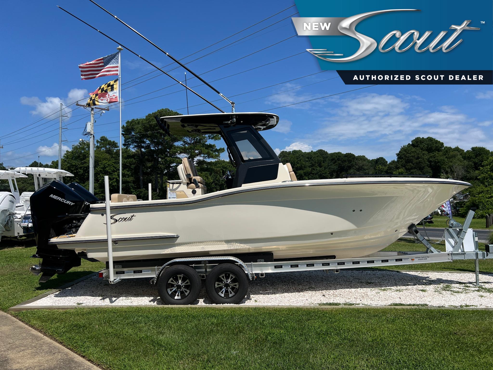 Scout 260 LXF 2025 Scout 260 LXF boat on trailer at authorized dealer, flags in background.