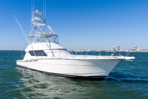 Hatteras 60 Convertible 1998 Hatteras 60 Convertible yacht cruising on open water under clear blue sky.