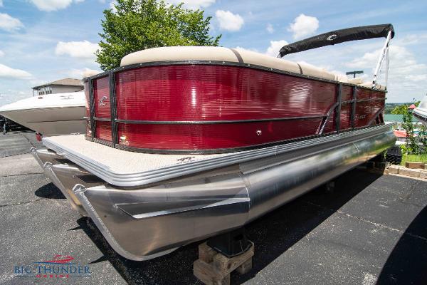 Crest CLASSIC LX 240 SLC 2023 Crest CLASSIC LX 240 SLC pontoon boat in red, docked on land.