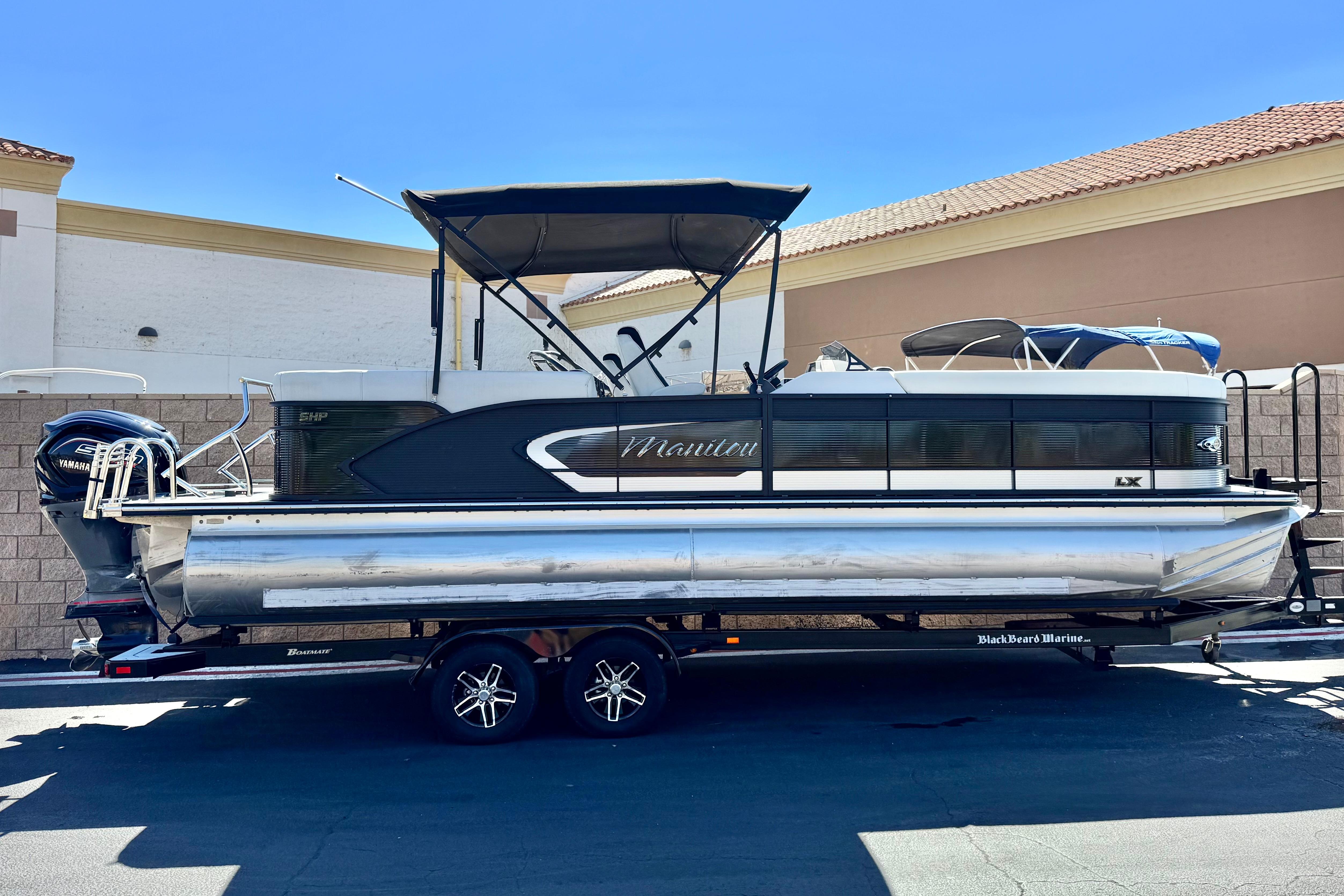 Manitou 25 LX SHP 2021 Manitou 25 LX SHP pontoon boat on trailer, parked outdoors.