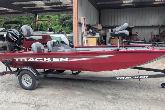 Tracker Pro 170 2026 Tracker Pro 170 boat in red, parked on a trailer in a garage.