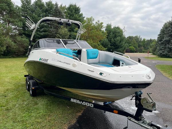 Custom Challenger 230 Custom 2012 Challenger 230 boat on trailer, parked on grass, surrounded by trees.