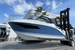 Sea Ray Sundancer 320 Outboard 2024 Sea Ray Sundancer 320 Outboard on forklift, blue and white hull, marina background.