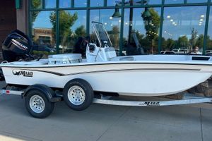 Mako Pro Skiff 15 CC 2026 Mako Pro Skiff 15 CC boat on trailer, parked outside a building.