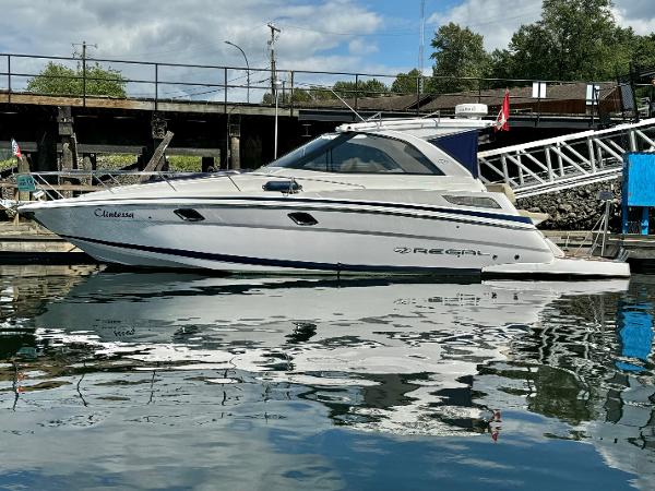 Regal 35 Sport Coupe 2012 Regal 35 Sport Coupe yacht docked in a marina, reflecting on calm water.