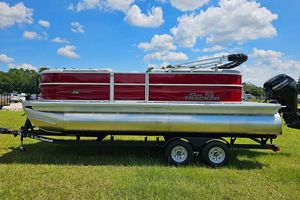 Sun Tracker Party Barge 20 DLX 2026 Sun Tracker Party Barge 20 DLX pontoon boat on trailer, parked on grass.