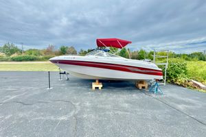 Four Winns 220 Horizon 1999 Four Winns 220 Horizon boat with red canopy on display outdoors.