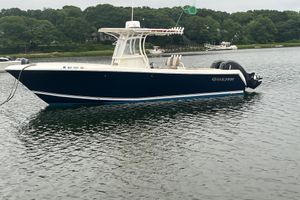 Sailfish 270 CC 2013 Sailfish 270 CC boat on calm water with lush green shoreline.