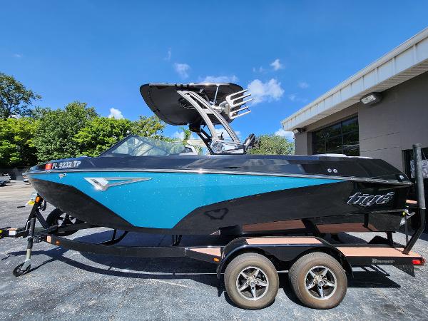 Tigé Z1 2022 Tigé Z1 boat on trailer, blue and black design, parked outdoors.