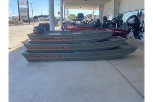 Tracker Grizzly 12 Jon Three stacked Tracker Grizzly 12 Jon boats, 2026 model, displayed outdoors.