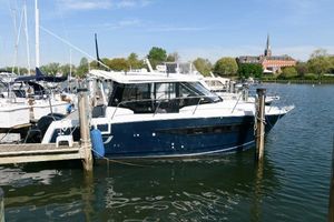 Jeanneau NC 895 2019 Jeanneau NC 895 boat docked in a marina with scenic background.