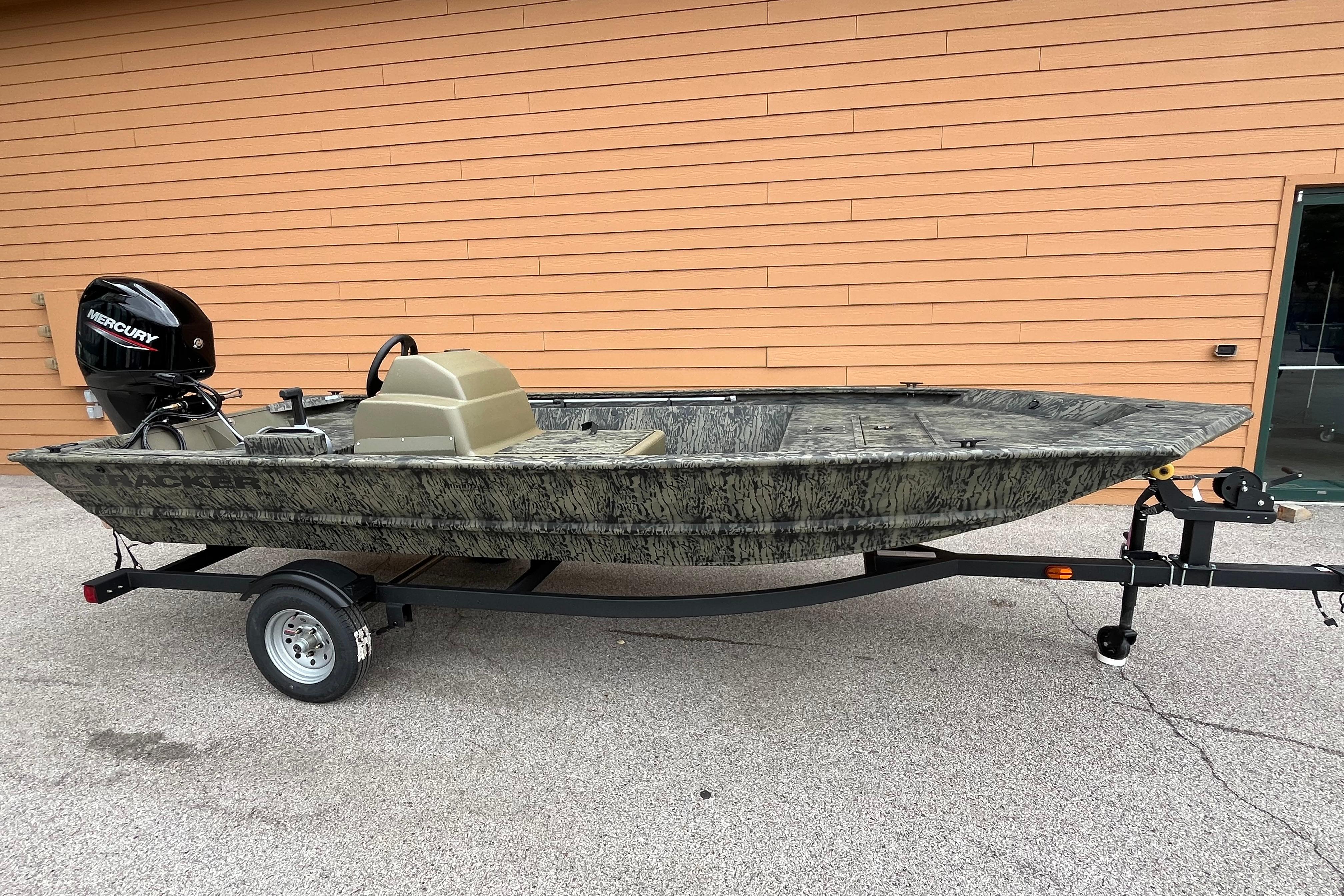 Tracker Grizzly 1648 SC 2026 Tracker Grizzly 1648 SC boat on trailer, camo design, Mercury outboard motor.