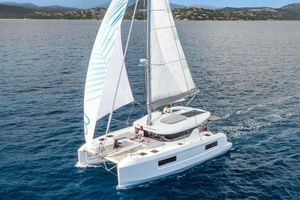 Lagoon 38 Manufacturer Provided Image: 2026 Lagoon 38 catamaran sailing on open sea with passengers relaxing on deck.