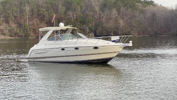 Maxum 3300 SCR 2000 Maxum 3300 SCR boat cruising on a calm lake with forested shoreline.