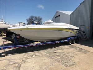 Baja 30 Outlaw 2005 Baja 30 Outlaw boat on trailer, parked outdoors near a warehouse.