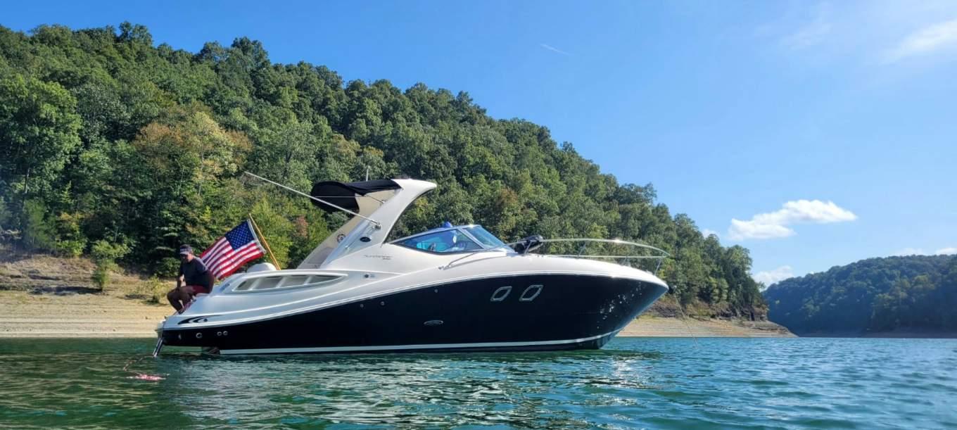 Sea Ray 310 Sundancer 2009 Sea Ray 310 Sundancer cruising on a scenic lake with lush green hills.