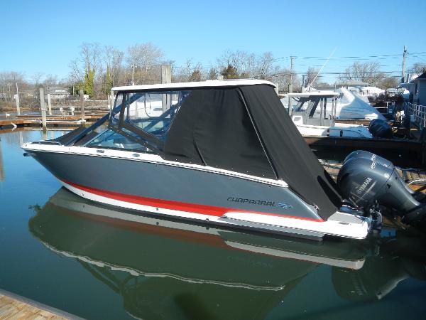 Chaparral 280 OSX 2023 Chaparral 280 OSX boat docked with black cover and outboard motor.