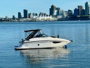 Regal 28 Express 2014 Regal 28 Express boat on calm water with city skyline in background.