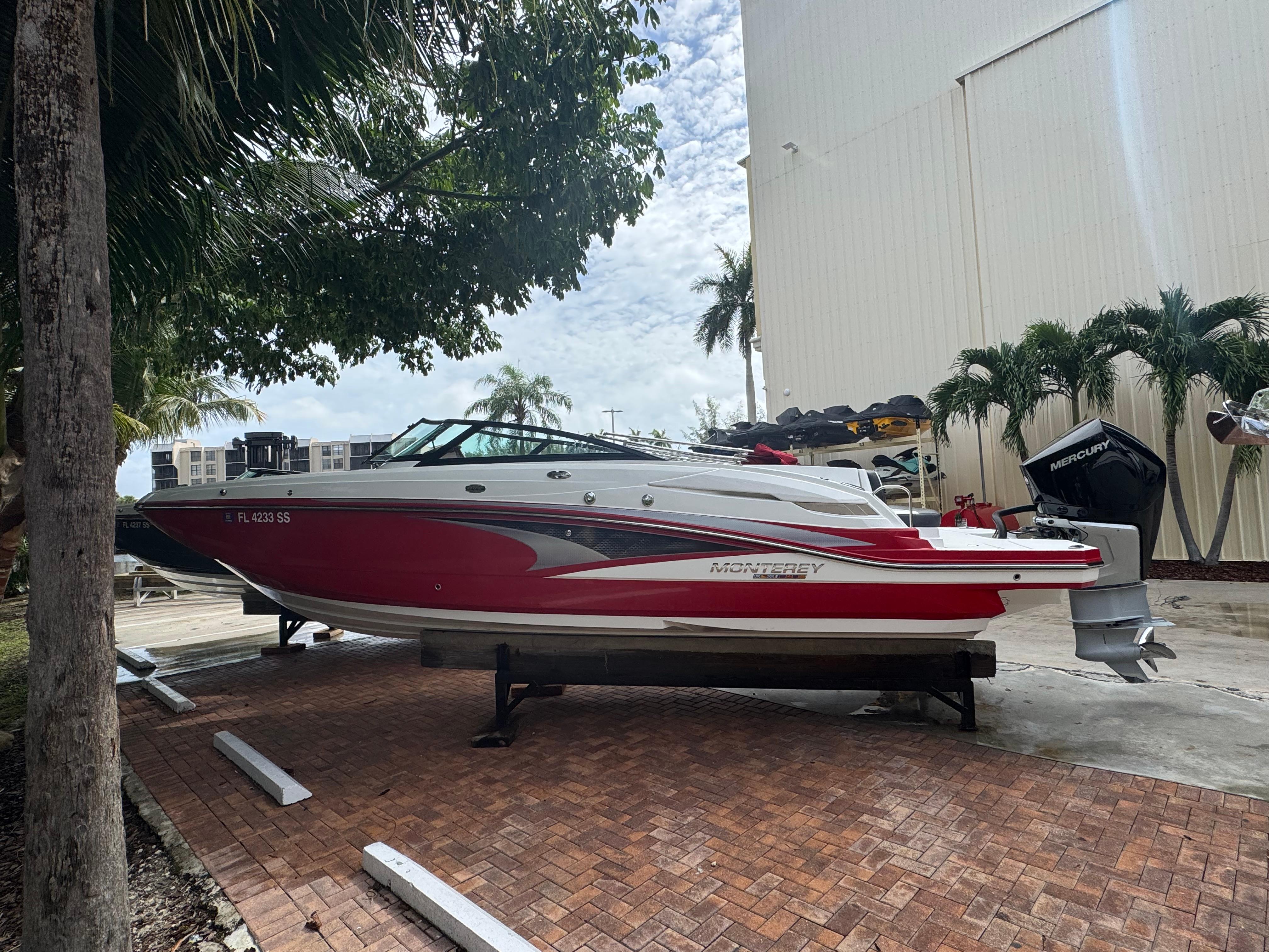Monterey M65 2020 Monterey M65 boat on display, red and white design, parked outdoors.