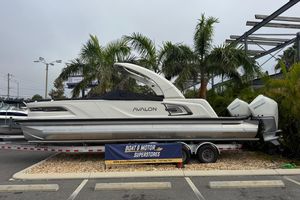 Avalon Excalibur - 27' 2026 Avalon Excalibur 27' boat displayed at dealership with palm trees in background.