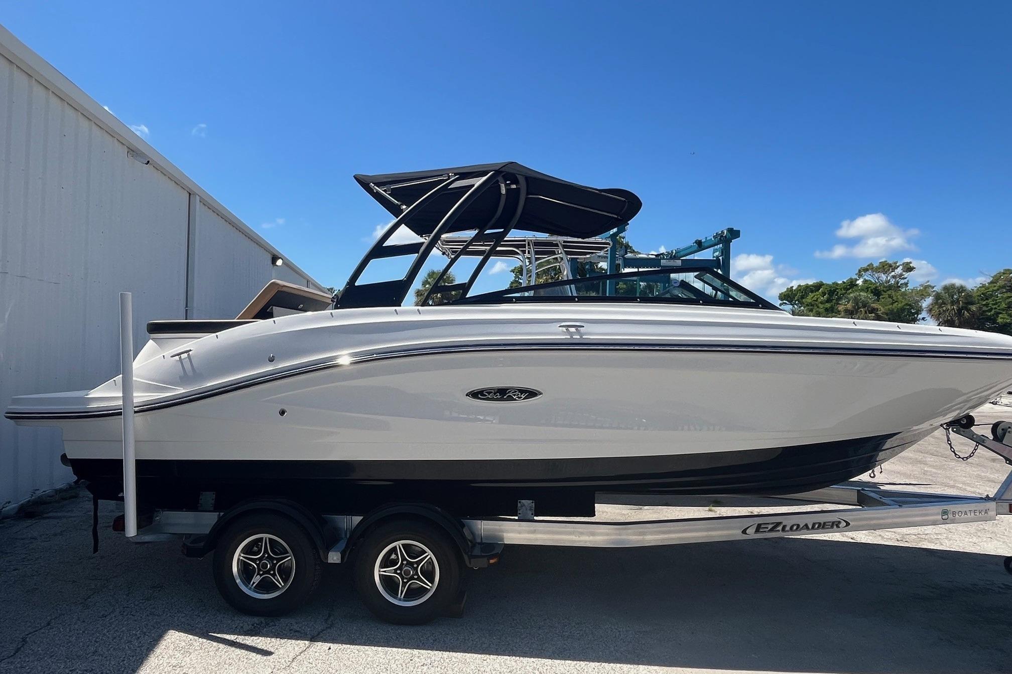 Sea Ray SPX 230 2024 Sea Ray SPX 230 boat on trailer, parked outdoors under clear blue sky.