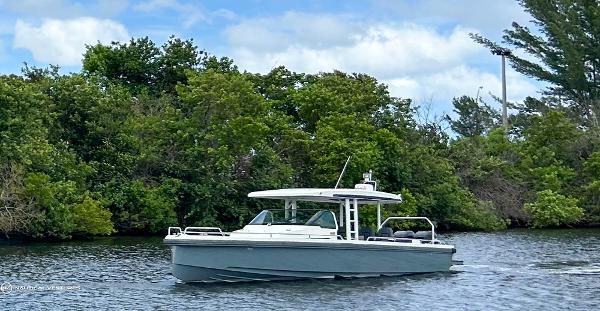 Axopar 37 Sun Top 2018 Axopar 37 Sun Top boat cruising on a calm river with lush greenery.