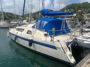 Prout Event 34 1990 Prout Event 34 catamaran docked in a marina, featuring blue accents and canopy.