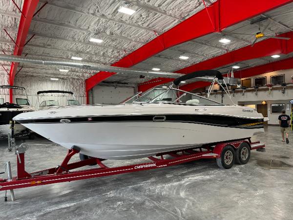 Four Winns 260 Horizon 2002 Four Winns 260 Horizon boat on a red trailer in a spacious indoor storage facility.