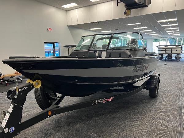 Alumacraft Competitor 175 Sport 2023 Alumacraft Competitor 175 Sport boat displayed indoors on a trailer.