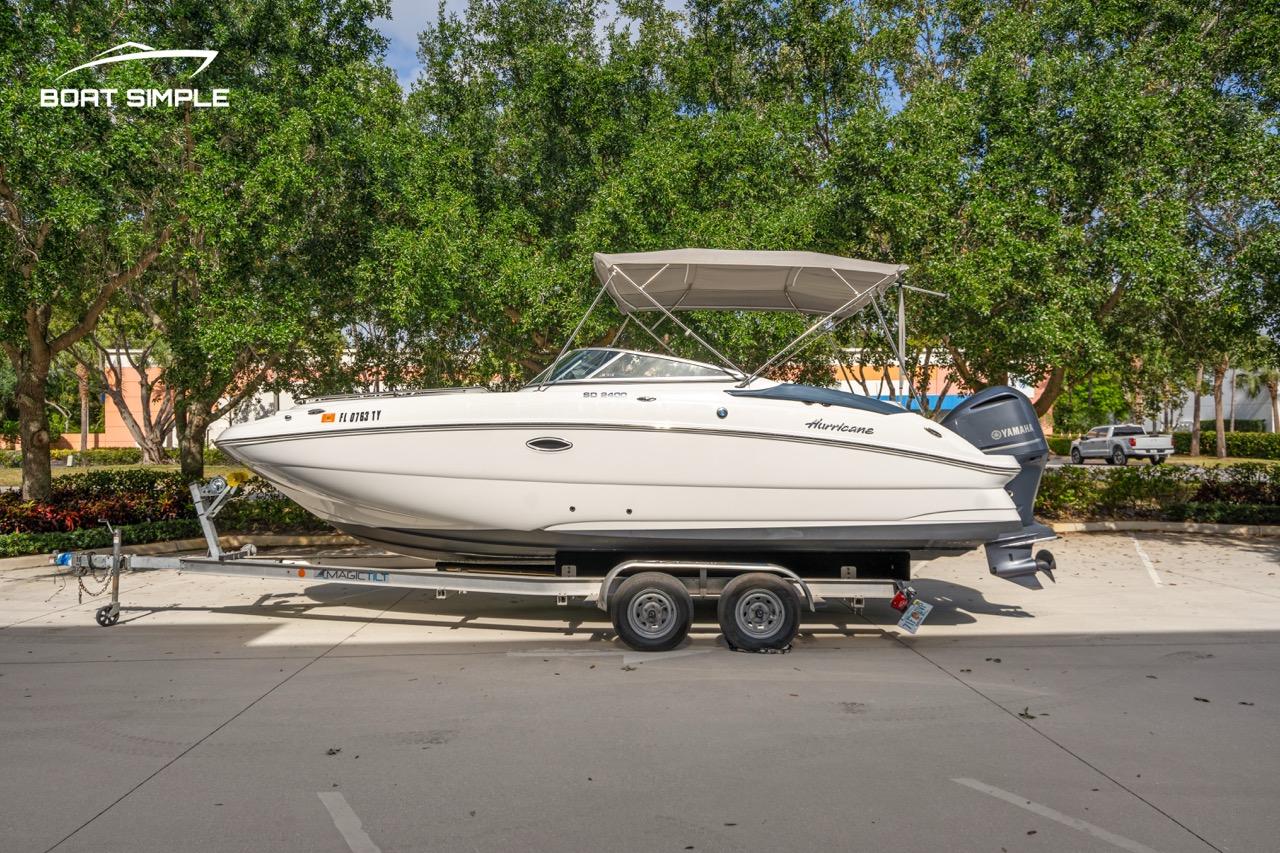 Hurricane SunDeck 2400 OB 2025 Hurricane SunDeck 2400 OB boat on trailer, parked outdoors with trees in background.