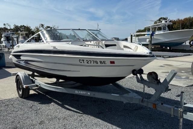 Glastron GT 185 2009 Glastron GT 185 boat on trailer, parked outdoors under clear sky.