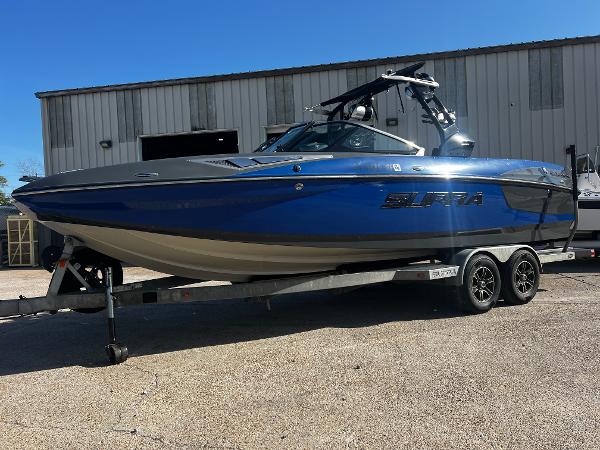 Supra SE450-550 2016 Supra SE450-550 boat in blue on a trailer, parked outside a warehouse.