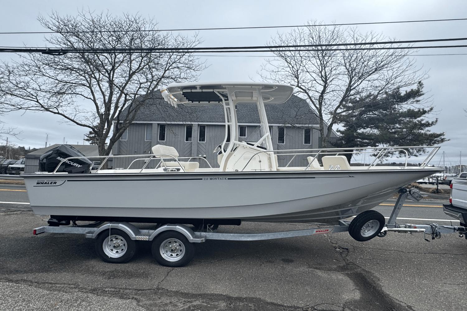 Boston Whaler 210 Montauk 2025 Boston Whaler 210 Montauk boat on trailer, parked outdoors.
